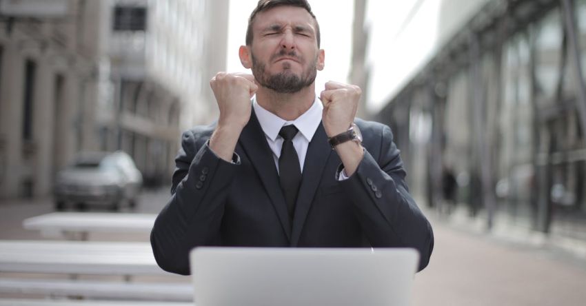 Ambition - Man in Black Suit Sitting on Chair Beside Buildings