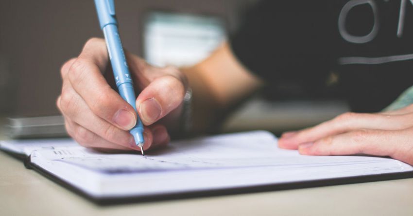 Writing - Person Holding Blue Ballpoint Pen Writing in Notebook