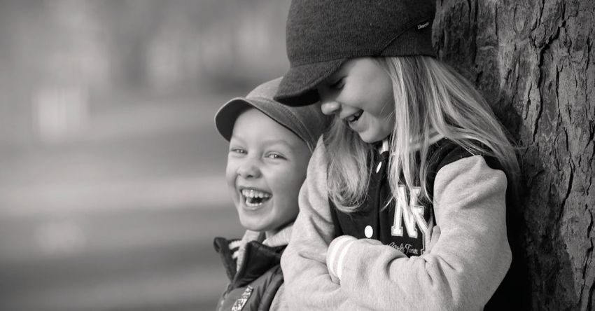 Laughter - Boy and Girl Leaning on Tree